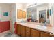 Bathroom boasts double sinks, wood cabinets, and a framed mirror reflecting the walk-in shower at 1913 Augustine Dr, The Villages, FL 32159