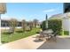 Outdoor patio with a dining set surrounded by manicured lawn and landscaping at 1913 Augustine Dr, The Villages, FL 32159