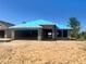 New construction shows cinder block exterior with vibrant blue roofing against a clear blue sky at 4365 Sw 90Th Pl, Ocala, FL 34476