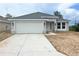 Charming single-story home with a two-car garage, gray facade, and well-manicured lawn at 4365 Sw 90Th Pl, Ocala, FL 34476