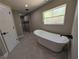 Luxurious bathroom featuring a modern freestanding tub and a large window at 6150 Sw 123 Ave Rd, Dunnellon, FL 34432