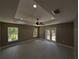 Bright bedroom with ceiling fan, tray ceiling, and views of nature at 6150 Sw 123 Ave Rd, Dunnellon, FL 34432
