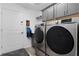 Modern laundry room with gray cabinets, stainless steel Samsung washer and dryer, and wood-look flooring at 6877 Minchew Cir, The Villages, FL 34762