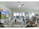 Bright living room features a ceiling fan, sliding glass doors to the lanai and a built-in media center at 6877 Minchew Cir, The Villages, FL 34762