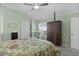 Well-lit main bedroom with a four-poster bed, ceiling fan, and ample closet space at 6877 Minchew Cir, The Villages, FL 34762