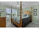 Inviting main bedroom showcasing a four-poster bed and sun-filled windows at 6877 Minchew Cir, The Villages, FL 34762