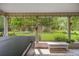 Enclosed back porch with tiled flooring and outdoor furniture overlooking a large lot at 760 Sw 89Th Ter, Ocala, FL 34481