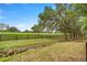 Sprawling green acreage with mature trees and a wooden fence line under a blue sky at 760 Sw 89Th Ter, Ocala, FL 34481