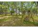 Relaxing backyard retreat with a wooden swing set overlooking the tree-lined acreage at 760 Sw 89Th Ter, Ocala, FL 34481