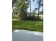 Home exterior with a grassy lawn, partially obscured by mature trees and shrubs at 845 Ne 130 Ter, Silver Springs, FL 34488