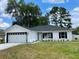 Charming single-story home with a well-maintained lawn, an attached two-car garage, and black trim on windows and roofline at 845 Ne 130 Ter, Silver Springs, FL 34488