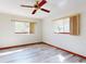 Bedroom featuring a ceiling fan, wood-style flooring, and two windows, creating a bright and inviting space at 11197 Sw 79Th Ave, Ocala, FL 34476