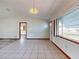Bright living room featuring tile floors, neutral walls, chandelier and natural light streaming through a large window at 11197 Sw 79Th Ave, Ocala, FL 34476