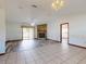 Open-concept living room with a stone fireplace, tile and laminate flooring, and sliding glass doors to the backyard at 11197 Sw 79Th Ave, Ocala, FL 34476