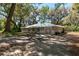 Charming single-story home with mature trees, a long driveway, attached garage, and light gray paint color at 14100 Ne 40Th Ct, Anthony, FL 32617
