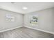 Bright bedroom with neutral walls, light wood floors, and windows overlooking the front yard at 2607 Verde Ln, Winter Park, FL 32792