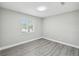 Minimalist bedroom featuring gray vinyl flooring, crisp white walls, and a bright window with ample natural light at 2607 Verde Ln, Winter Park, FL 32792