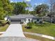 Inviting single-story home featuring a pristine driveway, lush lawn, and a convenient two-car garage at 2607 Verde Ln, Winter Park, FL 32792