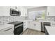 Updated kitchen featuring white cabinets, stainless steel appliances, gray subway tile backsplash, and modern countertops at 2607 Verde Ln, Winter Park, FL 32792