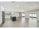 Open-concept living room with gray wood flooring and a kitchen with stainless steel appliances at 2607 Verde Ln, Winter Park, FL 32792