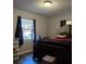 Bedroom with wood floors, natural light, and a dark wood bed at 911 Oak Dr, Leesburg, FL 34748