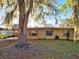 Charming single-story brick home featuring a classic design and inviting front yard with mature trees draped in Spanish moss at 911 Oak Dr, Leesburg, FL 34748