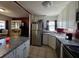 Well-lit kitchen with white cabinets, stainless steel appliances, and tile flooring, open to the dining area at 911 Oak Dr, Leesburg, FL 34748