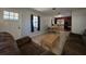 Inviting living room featuring tile flooring, a view of the dining area, and a bright front door at 911 Oak Dr, Leesburg, FL 34748