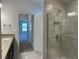 En-suite bathroom with a glass shower, sink with granite counter, and a doorway to a bedroom at 4528 Sw 90Th Lane Rd, Ocala, FL 34476