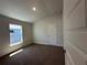 Carpeted bedroom with a large window, neutral walls, and a five-panel door at 4528 Sw 90Th Lane Rd, Ocala, FL 34476