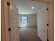 Bright, carpeted bedroom seen through an open doorway featuring neutral walls at 4528 Sw 90Th Lane Rd, Ocala, FL 34476