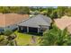 Aerial view of home featuring a gray tile roof, screened lanai, and landscaped yard at 9307 San Jose Blvd, Howey In The Hills, FL 34737