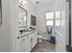 Bright bathroom with white vanity, granite countertops, square mirror, and tiled floors at 9307 San Jose Blvd, Howey In The Hills, FL 34737