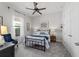 Bedroom with a ceiling fan, a bed with blue and white linens, and a large window at 9307 San Jose Blvd, Howey In The Hills, FL 34737