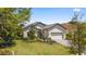 Beautiful single-story home featuring manicured landscaping, a paver driveway, and a two-car garage at 9307 San Jose Blvd, Howey In The Hills, FL 34737