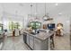 Open layout kitchen featuring granite countertops, gray island seating, wood look tile flooring and views of dining and living spaces at 9307 San Jose Blvd, Howey In The Hills, FL 34737