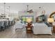 Open-concept living room with wood-look tile floors, stylish furnishings, and natural light from the backyard at 9307 San Jose Blvd, Howey In The Hills, FL 34737