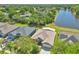 Aerial view of a home next to a pond with a spacious yard and mature trees at 1201 Creekview Ct, St Cloud, FL 34772