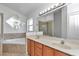 Bright bathroom with a double sink vanity, garden tub, shower, and decorative mirror at 1201 Creekview Ct, St Cloud, FL 34772