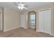 Beige bedroom featuring carpet, ceiling fan, closet, and natural light from the window at 1201 Creekview Ct, St Cloud, FL 34772