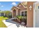 Tan house showcasing an arched entryway, manicured shrubbery, and a neatly maintained walkway at 1201 Creekview Ct, St Cloud, FL 34772