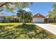 Front lawn view of tan home featuring an attached two-car garage at 1201 Creekview Ct, St Cloud, FL 34772