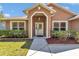 View of the house's front door and entryway, flanked by garden beds at 1201 Creekview Ct, St Cloud, FL 34772