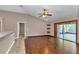 Living room with ceiling fan, hardwood floors, and sliding glass door at 1201 Creekview Ct, St Cloud, FL 34772