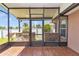 Outdoor kitchen under a screened lanai with stone accents, stainless steel grill, and bar seating at 1201 Creekview Ct, St Cloud, FL 34772