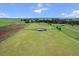 Aerial view of a beautiful single-story home with fenced pastures, outbuildings, and mature trees at 23376 Nw 27Th St, Morriston, FL 32668