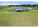 Expansive single-story home surrounded by lush green pastures and mature trees with a grand entrance at 23376 Nw 27Th St, Morriston, FL 32668