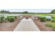 Tranquil outdoor fire pit area with stone seating, landscaping, and views of the lake at 5530 Nw 40Th Loop, Ocala, FL 34482