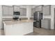 Modern kitchen featuring gray cabinets, stainless steel appliances, granite countertops and island with sink at 5530 Nw 40Th Loop, Ocala, FL 34482