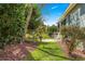 Scenic backyard with mature trees, beautiful flowerbeds, and a tranquil patio area at 9230 Sw 66Th Loop, Ocala, FL 34481